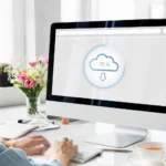 Počítač s ikonou cloudového úložiště na pracovním stole